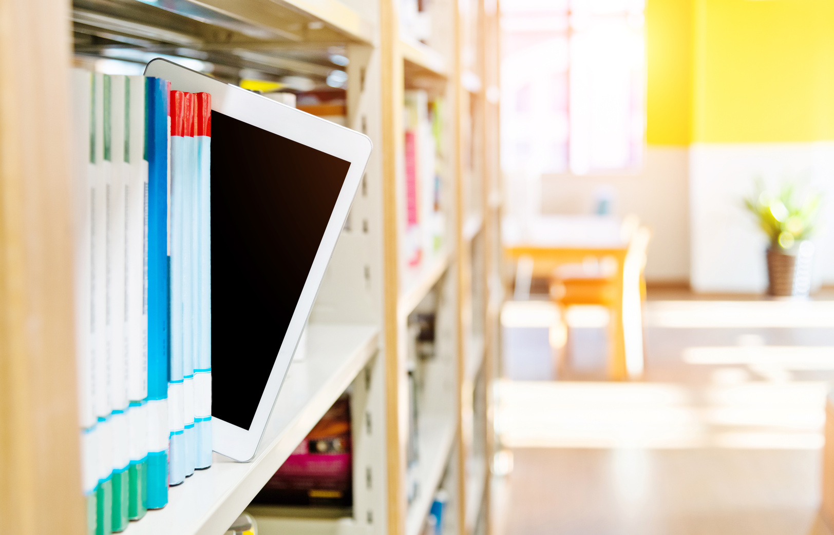 A digital tablet on library bookshelf